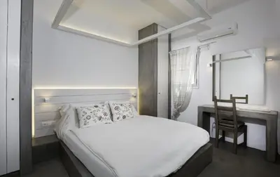 a bedroom with a bed and a desk with a chair at Lindian Pearl in Líndos