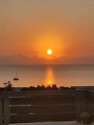 a sunset over the ocean with the sun in the sky at Ocean view Apartment in Rhodes Town