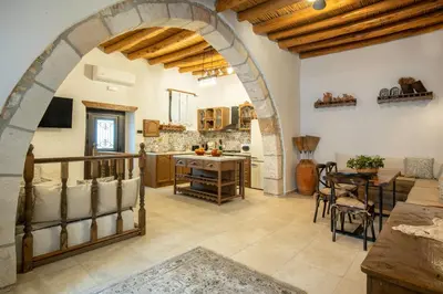 a kitchen with an archway and a table and chairs at Mareò Traditional Retreat in Archangelos