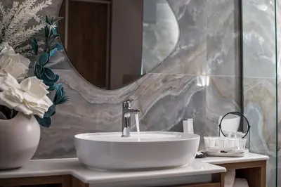 a bathroom with a sink and a mirror at Olea Luxury Apartment in Afantou