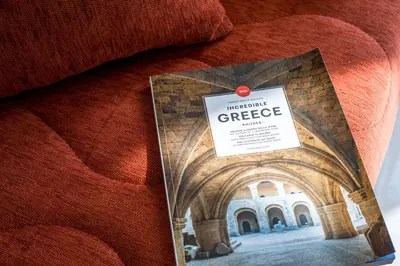 a book sitting on top of a bed at Olea Luxury Apartment in Afantou