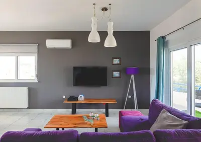 a living room with purple furniture and a tv at abk apartment in Afantou