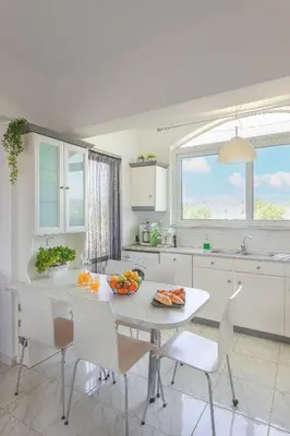 a kitchen with a table with a bowl of fruit on it at abk apartment in Afantou
