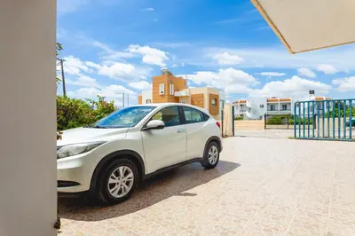 a white car parked in front of a building at abk apartment in Afantou