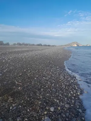a beach with rocks and the water on it at abk apartment in Afantou