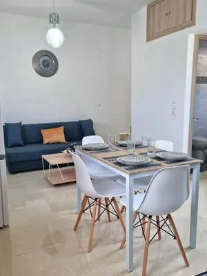 a dining table and chairs in a living room at Dionysia apartments in Livadia