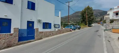an empty street with buildings and a car on the road at Dionysia apartments in Livadia
