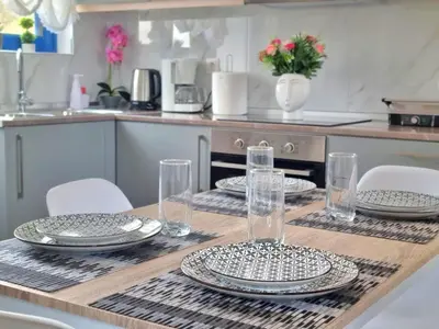 a table with plates and glasses on it in a kitchen at Dionysia apartments in Livadia