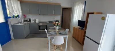 a kitchen with a table with chairs and a refrigerator at Dionysia apartments in Livadia