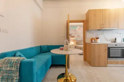 a living room with a blue couch and a table at Perfect Living in Rhodes Town