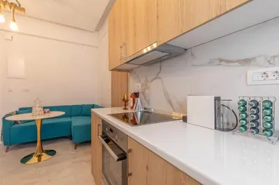 a kitchen with a sink and a blue couch at Perfect Living in Rhodes Town