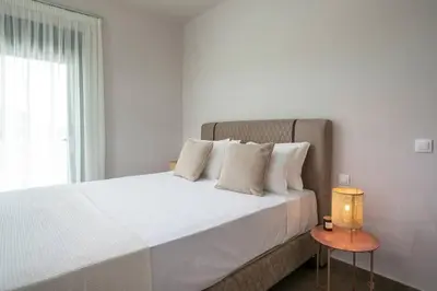 a bedroom with a large white bed with a lamp at Villa Aurora in Faliraki