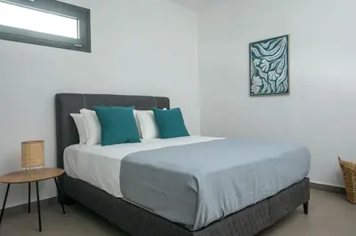 a bedroom with a bed with blue and white pillows at Villa Aurora in Faliraki