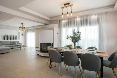 a dining table and chairs in a living room at Villa Aurora in Faliraki