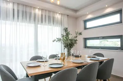 a dining room with a wooden table and chairs at Villa Aurora in Faliraki