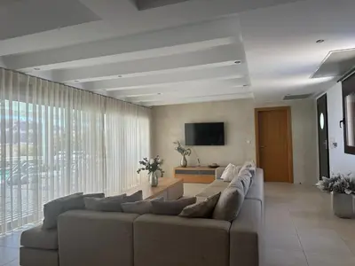 a living room with a couch and a flat screen tv at Solis Lindos Villa in Líndos