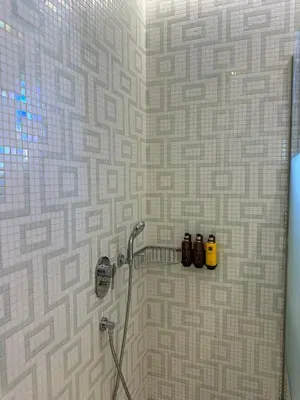 a bathroom with a shower with three bottles of soap at Solis Lindos Villa in Líndos