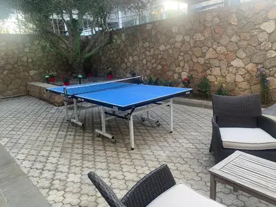 a ping pong table on a patio with two chairs at Solis Lindos Villa in Líndos