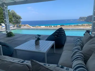 a patio with a couch and a table next to a pool at Solis Lindos Villa in Líndos