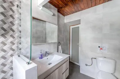 a white bathroom with a sink and a toilet at Beach House Cavo Kiotari in Gennadi