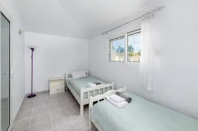 a white room with two beds and a window at Beach House Cavo Kiotari in Gennadi