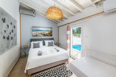 a bedroom with a large bed and a balcony at Beach House Cavo Kiotari in Gennadi
