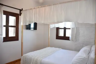 a bedroom with a bed and two windows at MOM'S RETREAT in Siána