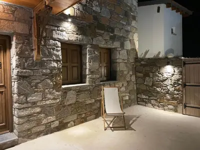 a chair sitting in front of a stone wall at MOM'S RETREAT in Siána