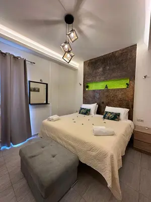 a bedroom with a large bed and a green painting on the wall at JZ Boutique 2 in Rhodes Town