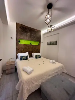 a bedroom with a large bed with a green painting on the wall at JZ Boutique 2 in Rhodes Town