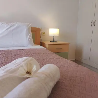 a bedroom with a bed with a white flower on it at Aithrea's HOMES in Pastida Rhodes in Pastida