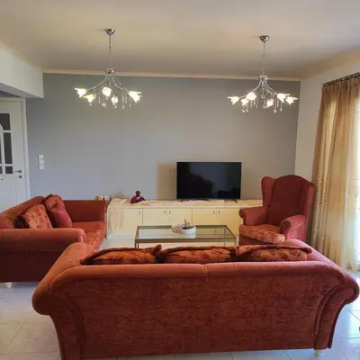 a living room with a couch and a tv at Aithrea's HOMES in Pastida Rhodes in Pastida