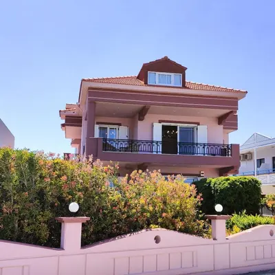 a house with a balcony and bushes in front of it at Aithrea's HOMES in Pastida Rhodes in Pastida