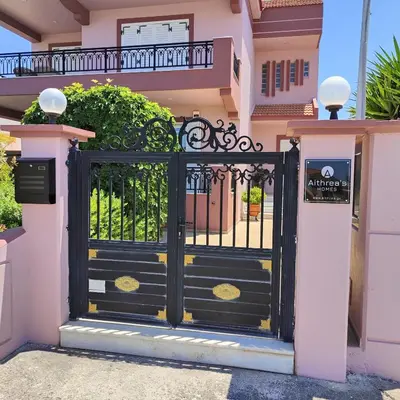 a black gate in front of a pink house at Aithrea's HOMES in Pastida Rhodes in Pastida