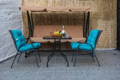 two chairs and a table with a drink and a bowl of fruit at Irinis studio in Rhodes Town