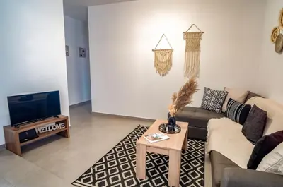 a living room with a couch and a tv at Maquestas Modern Apartments in Archangelos