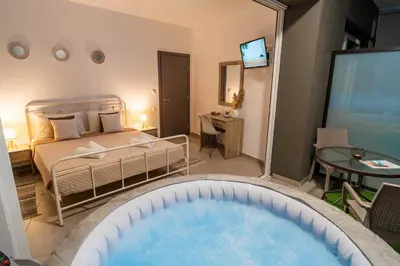 a bedroom with a bed and a tub in a room at Maquestas Modern Apartments in Archangelos