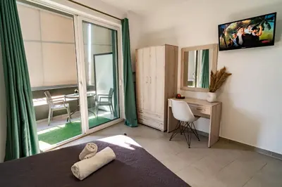 a bedroom with a bed and a desk and a window at Maquestas Modern Apartments in Archangelos