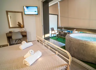 a room with a bed and a bathroom with a tub at Maquestas Modern Apartments in Archangelos