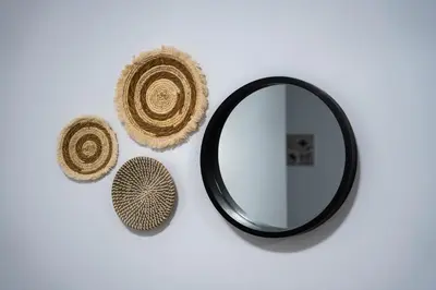 a mirror and a straw hat on a wall at Maquestas Modern Apartments in Archangelos
