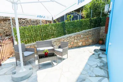 two chairs and a table under a white umbrella at Aelia studio in Symi