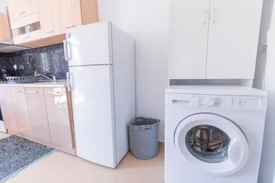 a kitchen with a washing machine and a refrigerator at Aelia studio in Symi