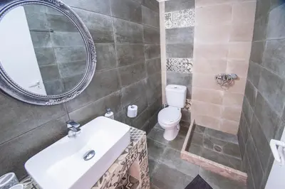 a bathroom with a sink and a toilet and a mirror at Aelia studio in Symi