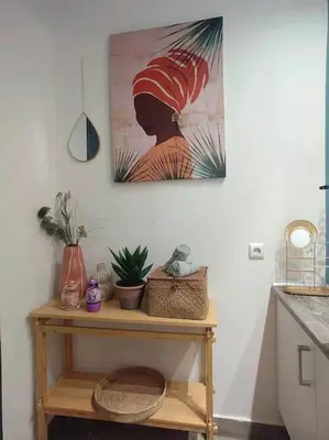 a table with plants and a painting on the wall at The Cozy Nest in Rhodes town in Rhodes Town