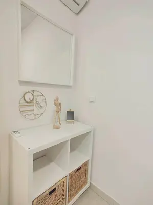 a white room with a shelf and a mirror at The Cozy Nest in Rhodes town in Rhodes Town