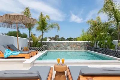 a swimming pool with a patio furniture and a villa at Aqua Villa Faliraki in Faliraki