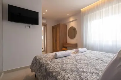 a bedroom with a bed and a flat screen tv at Aqua Villa Faliraki in Faliraki
