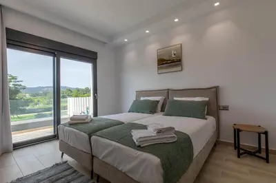 a bedroom with a bed and a large window at Armonia Luxury Villa in Triánta