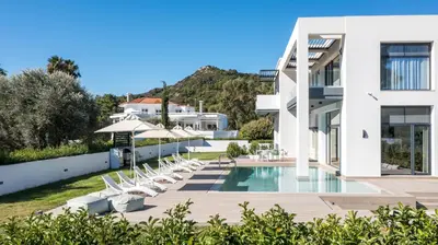 a villa with a swimming pool and lounge chairs at Armonia Luxury Villa in Triánta