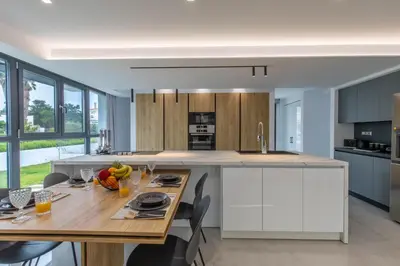 a kitchen with a wooden table and a large island at Armonia Luxury Villa in Triánta